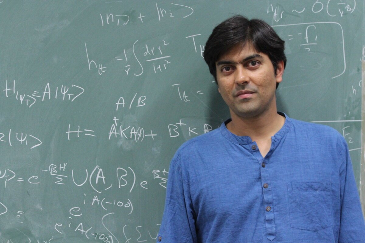 Suvrat Raju in front of a blackboard